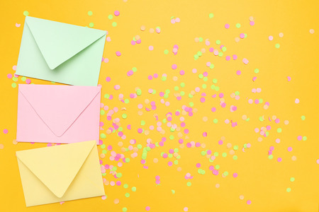 Colorful envelopes with confetti on yellow backgroundの写真素材