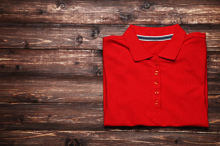 Folded t-shirt on brown wooden tableの写真素材