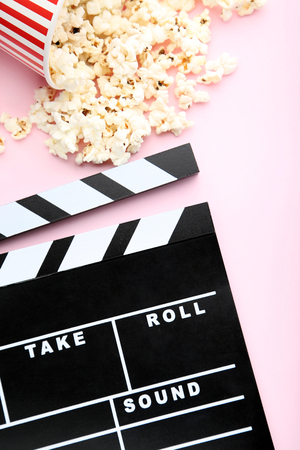 Clapper board with popcorn on pink backgroundの写真素材