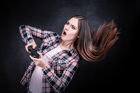 Beautiful girl with joystick on black backgroundの写真素材