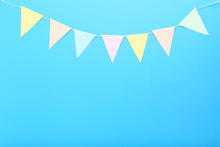 Paper flags hanging on blue background