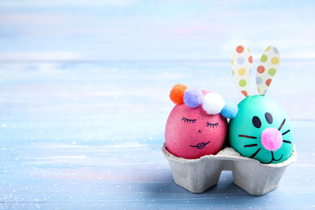 Cute easter eggs on blue wooden tableの写真素材