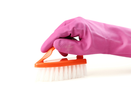 Female hand holding cleaning brush on white backgroundの写真素材