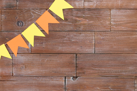 Paper flags hanging on brown wooden backgroundの写真素材