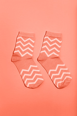 Pair of socks on coral background. Minimalism conceptの写真素材