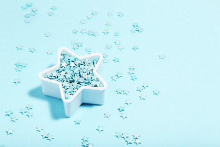 Star with sprinkles on blue background. Minimalism concept