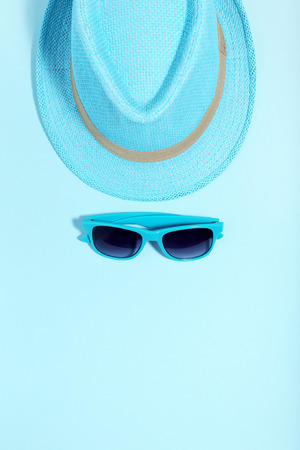 Sunglasses with hat on blue background. Minimalism conceptの写真素材