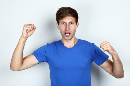 A handsome young man in blue t-shirt on grey backgroundの写真素材