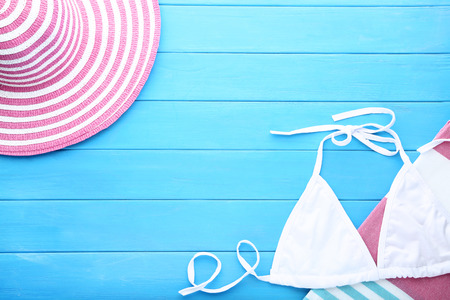 Swimsuit with towels and hat on wooden tableの写真素材