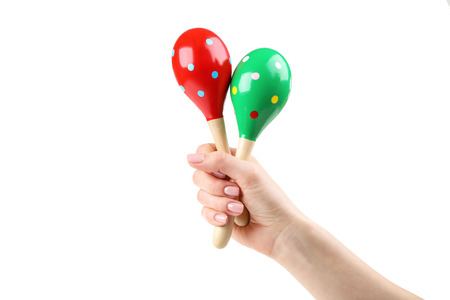 Mexican maracas in female hand on white background