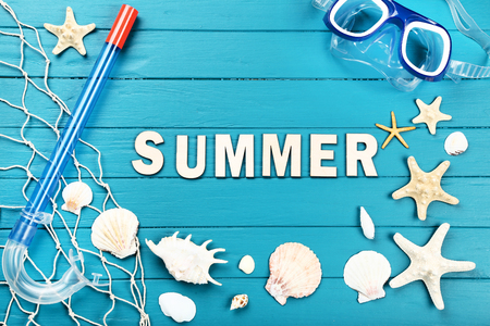 Word Summer with seashells, diving mask and snorkel on blue wooden tableの写真素材