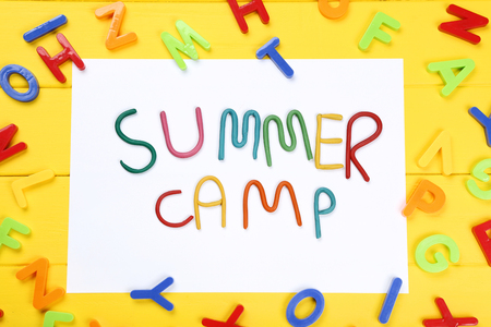 Text Summer camp with plastic letters on yellow wooden tableの写真素材