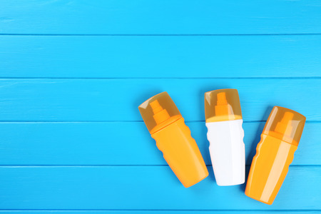 Sunscreen bottles on blue wooden tableの写真素材