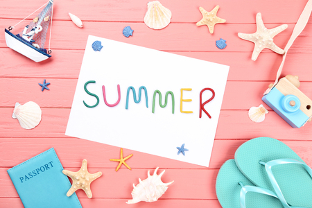 Word Summer with seashells, passport and flip flops on wooden tableの写真素材