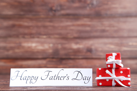 Text Happy Fathers Day with gift boxes on wooden tableの写真素材