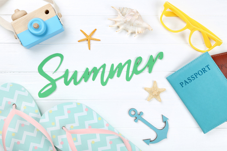 Word Summer with seashells, flip flops, passport and glasses on white wooden tableの写真素材
