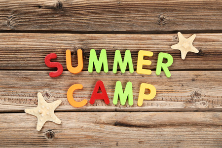 Text Summer camp with starfishes on brown wooden tableの写真素材