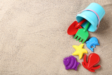 Colorful plastic toys on beach sandの写真素材