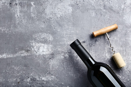 Wine bottle with cork and corkscrew on grey wooden tableの写真素材