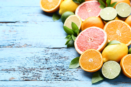 Citrus fruits with green leafs on blue wooden tableの写真素材