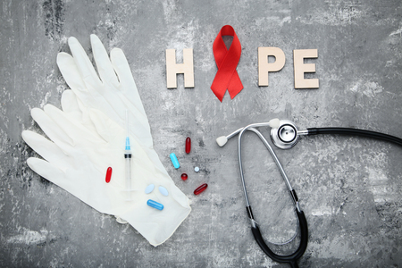 Red ribbon with pills, syringe and stethoscope. Medicine conceptの写真素材