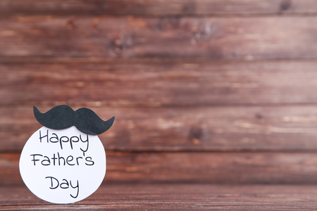 Text Happy Fathers Day with black mustache on wooden tableの写真素材