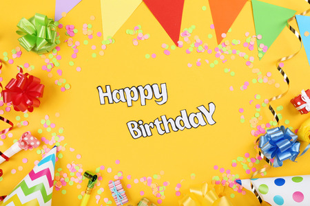 Text Happy Birthday with party decorations on yellow backgroundの写真素材
