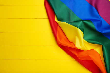 Rainbow flag on yellow wooden tableの写真素材