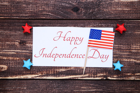 Text Happy Independence Day with paper stars and flag on brown wooden tableの写真素材