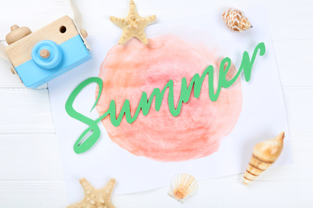 Word Summer with seashells and retro camera on white wooden tableの写真素材