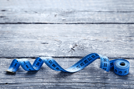 Blue measuring tape on grey wooden tableの写真素材