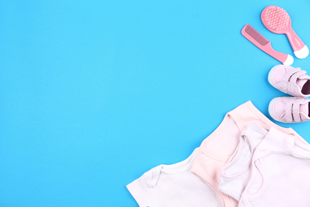Clothes with baby supplies on blue backgroundの写真素材