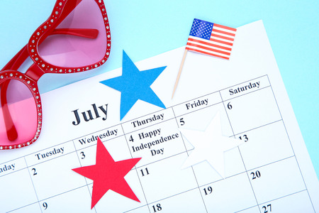 Text Happy Independence Day in calendar with american flag and sunglasses on blue backgroundの写真素材