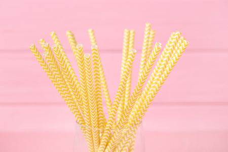 Yellow paper straws on pink backgroundの写真素材