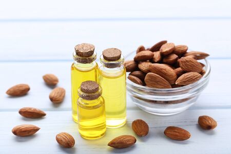 Almond and oil in bottles on wooden tableの写真素材