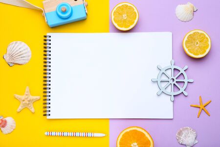 Blank sheet of paper with seashells and orange fruits on colorful backgroundの写真素材