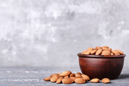 Almonds in bowl on grey wooden tableの写真素材