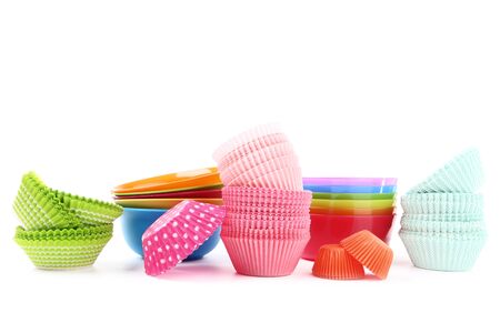 Cupcake cases with colorful bowls on white backgroundの写真素材