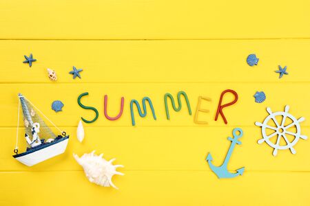 Word Summer with seashells and decorative ship on yellow wooden tableの写真素材