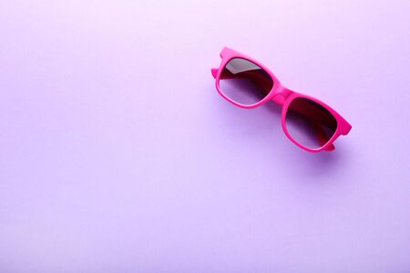 Modern sunglasses on purple background