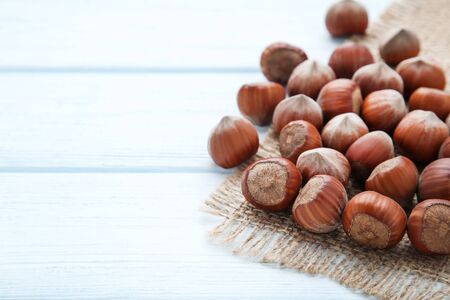 Ripe hazelnuts with sackcloth on wooden tableの写真素材