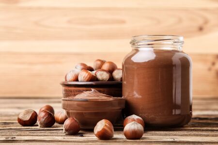 Melted chocolate with hazelnuts on brown wooden tableの写真素材