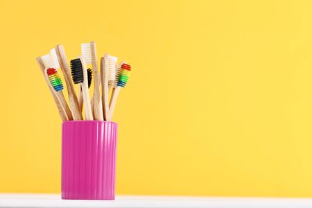 Bamboo toothbrushes in basket on yellow backgroundの写真素材
