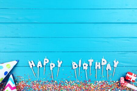 Happy Birthday candles with decorations and sprinkles on wooden tableの写真素材