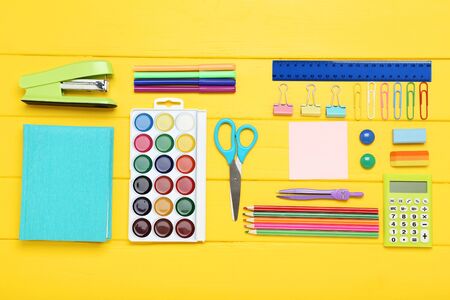 School supplies on yellow wooden tableの写真素材