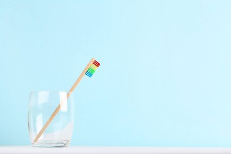 Bamboo toothbrush in glass on blue backgroundの写真素材