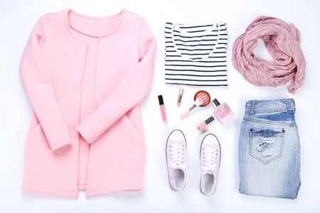Modern women's clothes with cosmetics on white background