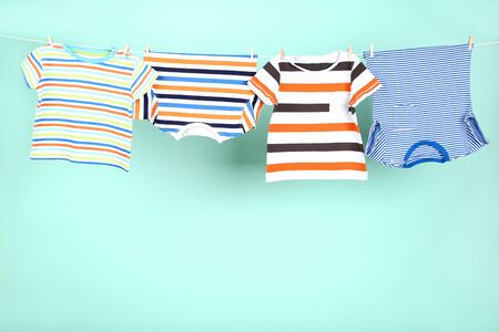 Baby clothes hanging on blue backgroundの写真素材