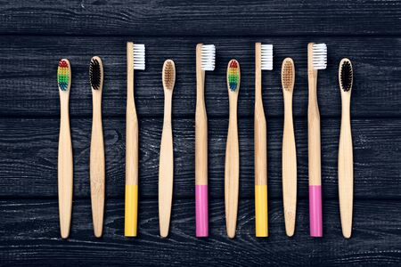 Bamboo toothbrushes on black wooden table