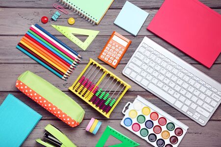 School supplies with keyboard on wooden table